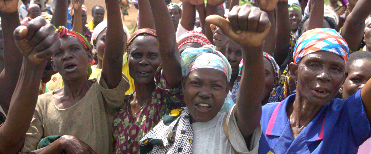 Women gathering, fists raised in solidarity at Pendeza Africa (PENAF)